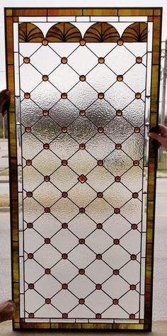 a person holding up a stained glass door