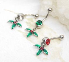 "Christmas Holly Belly Ring 14g surgical stainless steel belly bar features a festive holiday charm with bright enamel colors. Belly button ring measures 1 1/2 inches long total length. Barbell is 14g surgical steel. Top ball measures 5mm, bottom ball measure 8mm. Charms are made from a \"pewter\" (zinc-based alloy) base. For Belly Button Rings: https://www.etsy.com/shop/AllAboutClass?section_id=18474235&ref=shopsection_leftnav_1 All body jewelry sales are final!! AllAboutClass DOES NOT accept a Christmas Belly Button Rings, Cute Belly Rings, Belly Bar, Belly Bars, Button Rings, Belly Button Ring, Belly Piercing, Button Ring, Tanning Lotion