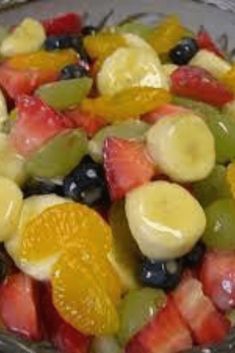 a glass bowl filled with fruit salad on top of a table