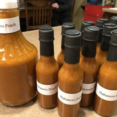 several bottles of hot sauce are lined up on the counter