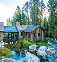 this is an image of a house in the woods with rocks and trees around it