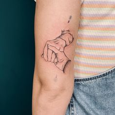 a woman's arm with a tattoo on it that has a hand holding something