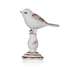 a white and brown bird sitting on top of a wooden stand with its head turned to the side