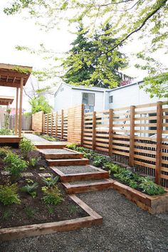 an outdoor garden with steps leading up to the deck and pergolated planter area