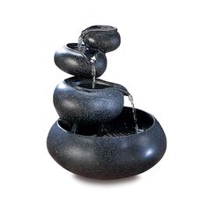 a black water fountain with three rocks stacked on top of each other and flowing water