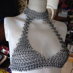 a white mannequin with silver chains on it's neck and bottom part