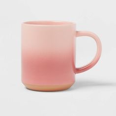 a pink coffee mug sitting on top of a white table