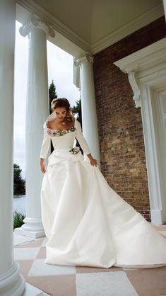 a woman in a white wedding dress is posing for the camera