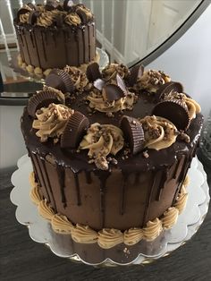 two cakes with chocolate frosting and peanut butter toppings are on a plate next to a mirror