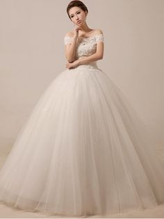 a woman in a white wedding dress posing for the camera with her hand on her chin