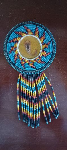 a beaded brooch with an image of a woman's face on it