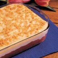 a casserole dish is sitting on a blue towel next to pink roses and tulips