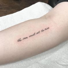 a person with a tattoo on their arm that says, the sun must not rise