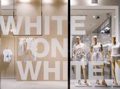 three mannequins are in the window of a white on white clothing store