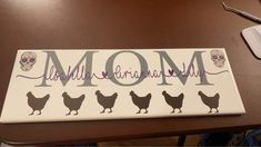 a sign that says mom with chickens and skulls on the bottom, sitting on a table