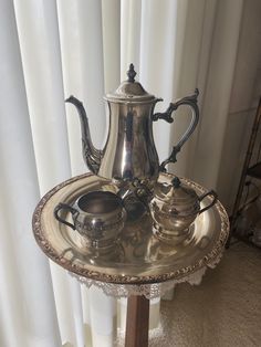 a silver tea set sitting on top of a metal tray