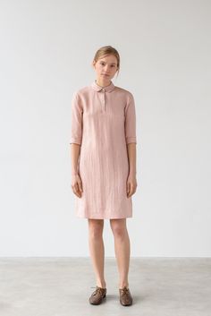 "An A-cut dress made from a soft linen fabric and partial button fastening, 3/4 sleeves and a straight hemline. -  Shirt collar with rounded points -  Set-in 3/4 sleeves closes with wide cuffs -  Partial button fastening -  Bust darts -  Inverted back pleat -  Straight hemline -  Knee length -  Unlined Ready to ship. Material & manufacturing Made in Lithuania from local medium weight 100% Oeko-Tex certified linen fabric and mother of pearl buttons.   Color -  light pink  *Due to the unique properties of linen and its manufacturing process, the colors between batches can change slightly. Size & fit View size guide in the last picture. Model is 176cm (5'9\") tall and is wearing a XS. Length from shoulder:  XS - 98cm / 38,5\" If you're not sure about a product's size, we would be glad to help Elegant Linen Dress With 3/4 Sleeves, Spring Linen Dress With Half Sleeves, Collared Linen Dress For Spring Daywear, Collared Linen Dress For Workwear, Long Sleeve Linen Dress With Placket, Collared Linen Day Dress, Collared Linen Daywear Dresses, Collared Linen Summer Dresses, Collared Linen Dress For Daywear