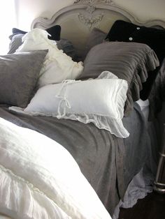 an unmade bed with pillows and blankets on it