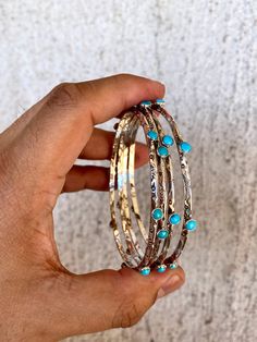 This stunning stack of stamped bangles, crafted by Navajo artist Evelyn Bahe, features a one-of-a-kind combination of .925 Sterling Silver and eight round bright blue turquoise stones. Each stone is hand-selected, making each bangle unique. Get one or purchase more to your collection for a flirty and captivating look. ONE PER ORDER. Bohemian Stackable Bracelet Jewelry, Bohemian Stackable Jewelry For Festivals, Adjustable Hammered Turquoise Jewelry, Southwestern Style Jewelry With Oxidized Finish, Stackable Round Beaded Bracelets In Bohemian Style, Artisan Hammered Turquoise Jewelry, Artisan Stackable Round Jewelry, Artisan Stackable Jewelry, Stackable Turquoise Jewelry For Festivals