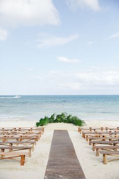 an empty beach with rows of wooden benches