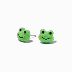 a pair of frog earrings with green glittery eyes and smiling face on the front