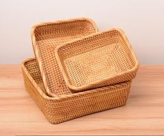 two wicker trays sitting on top of a wooden table next to each other