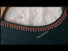 a close up of a black dress with red and white beads