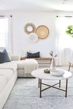 a living room filled with white furniture and lots of pillows on top of it's walls