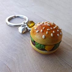 a hamburger keychain sitting on top of a wooden table