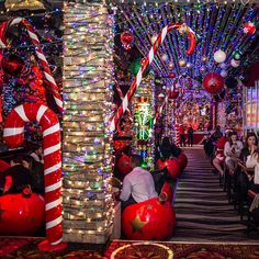 people are standing in the hallway decorated with christmas lights and candy canes on display