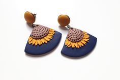 a pair of sunflower shaped earrings on top of a white surface