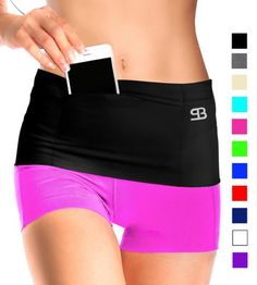 a woman in pink and black shorts is holding a cell phone to her hip pocket