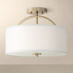 a light fixture hanging from the ceiling in a room with beige walls and flooring