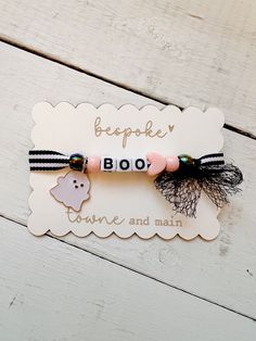 a white and black bracelet with a ghost on it's side that says bespie boo