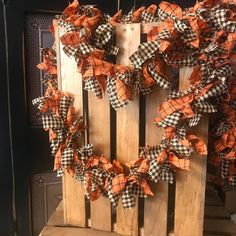 an orange and black wreath on top of a wooden crate