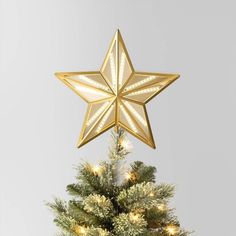 a gold star decoration on top of a christmas tree