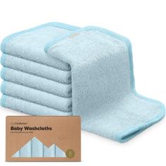 baby washcloths are stacked on top of each other in front of a box