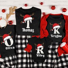 three matching christmas pajamas and onesuits with the letter k on them, sitting next to decorations