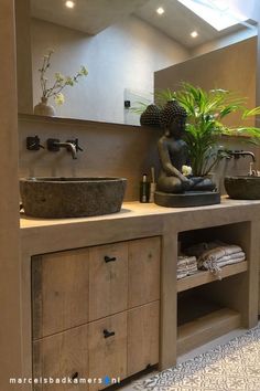 a bathroom with two sinks and a large mirror on the wall next to a potted plant