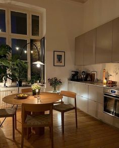 a table and chairs in a small room with a window overlooking the city at night