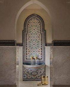 an ornate sink in the middle of a room with marble walls and floor tiles on it