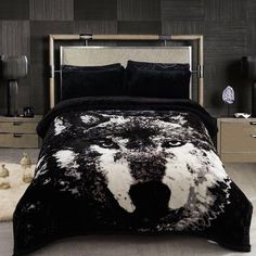 a black and white bed with a wolf head on it's comforter in a bedroom