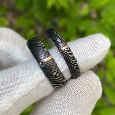 Gorgeous His & Her Damascus Ring Set. The Men's Ring is 6mm wide with a 1 millimeter vertical 14k rose gold inlay and the women's ring is 4mm wide with a 1 millimeter 14k rose gold inlay. Each ring is made to order by some of the best jewelry artisans that the industry has to offer. Our Damascus steel rings have an inside comfort fit to ensure that the ring will rest comfortably on your finger throughout the day and fits perfectly. This uniquely styled ring also has a two-tone finish with a Rings His And Hers, Adjustable Carved Rings For Anniversary, Black Etched Rings For Anniversary, Black Anniversary Rings With Engraving Option, Black Jewelry With Engraving Option For Anniversary, Anniversary Black Etched Rings, Black Etched Rings As A Gift, Damascus Wedding Band Men, Damascus Ring For Women