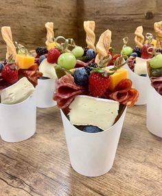 small cups filled with fruit, cheese and crackers