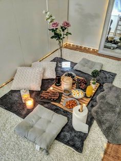 a table with food and candles on it in the middle of a living room area