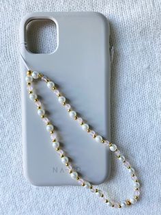 a white phone case with pearls on it