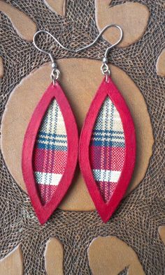 two pairs of red and white plaid leather earrings with silver hooks on a brown background