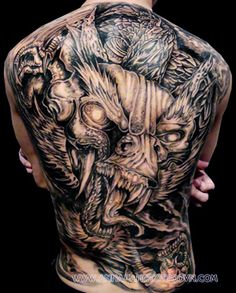 the back of a man's body with tattoos on it and an image of a demon