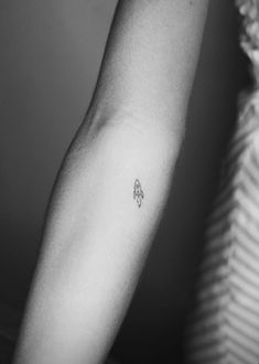 a woman's arm with a small tattoo on the left side of her arm