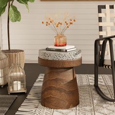 a table with some books on top of it next to a chair and potted plant